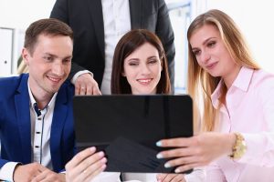 Group of people in office look at mobile tablet pc